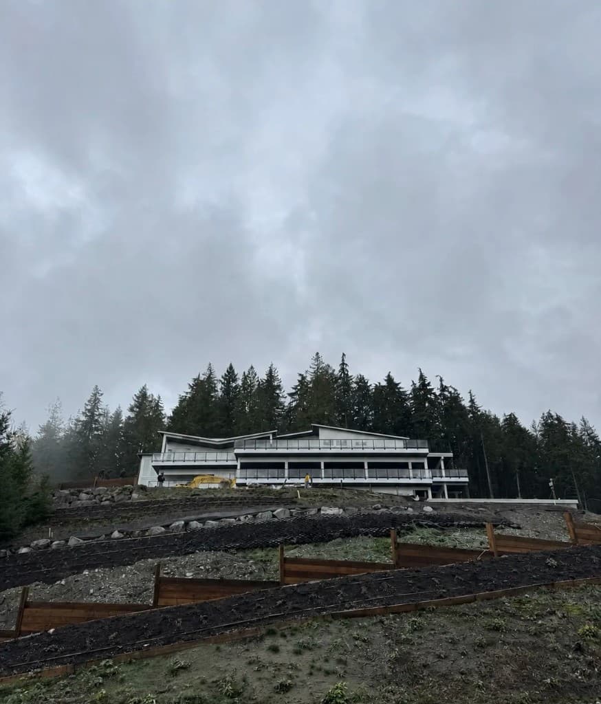 Luxury hillside home under construction with roof structure in progress