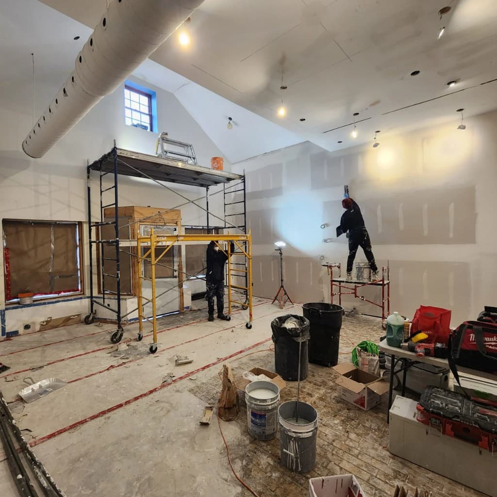 Commercial restaurant interior under construction with drywall and scaffolding